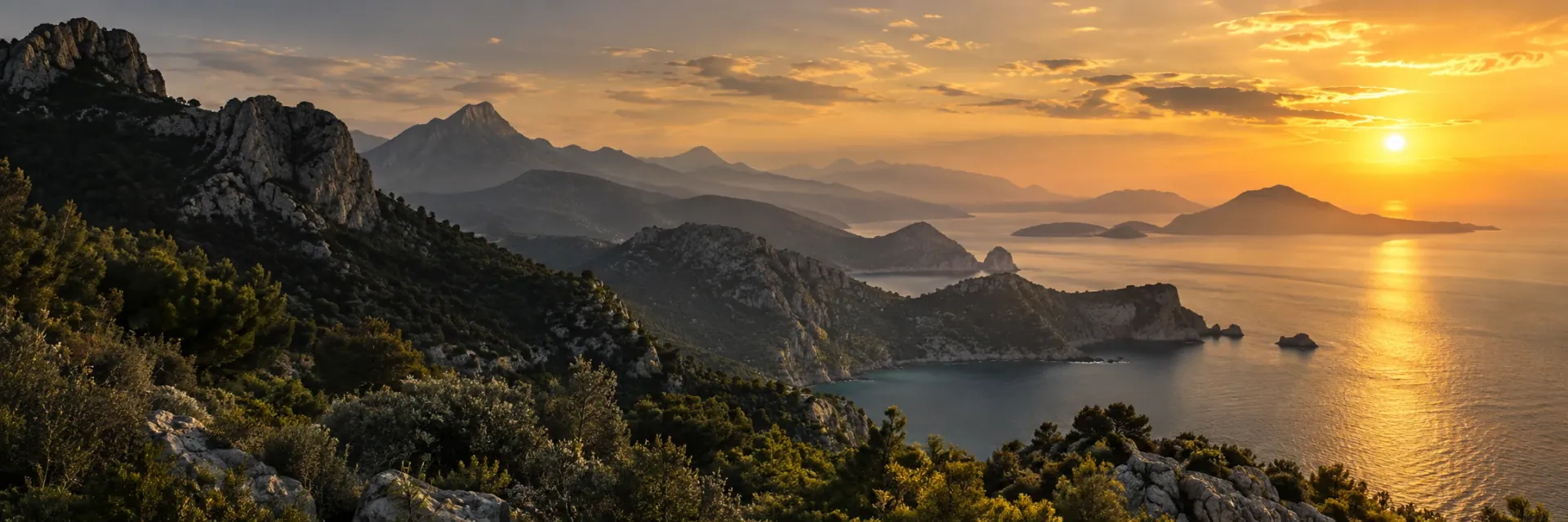 Golden sunset over rugged coastal mountains and a quiet sea.